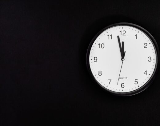 black round analog wall clock on black background