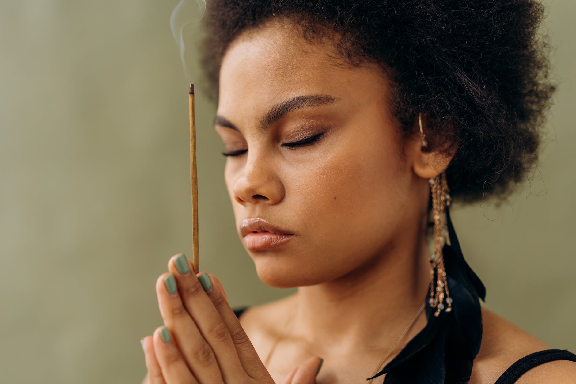 woman with eyes closed holding an incense