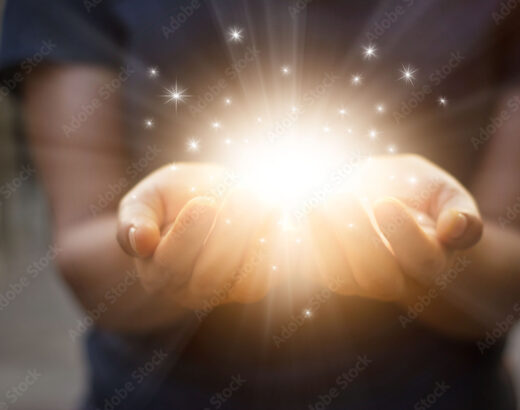 Stardust and magic in woman hands on dark background